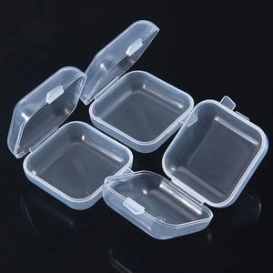 Set of four clear mini plastic storage boxes with flip lids on a black surface