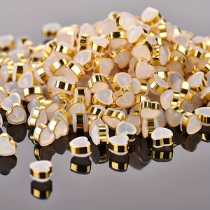 Bulk heart-shaped silicone earrings backs with gold metal trim displayed on a dark surface