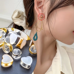 Macro detail of heart-shaped silicone earring backs in gold, silver and clear styles