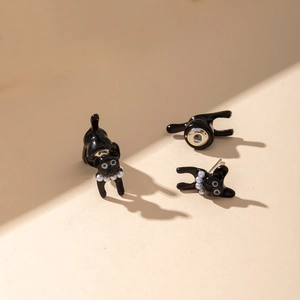 Detalle de pendientes 3D de bulldog francés en esmalte negro con perla pequeña