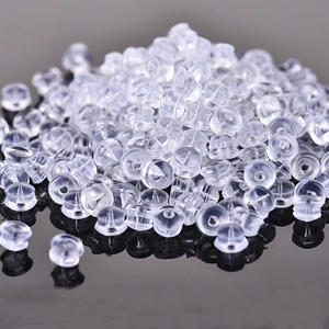 Macro shot of bulk transparent silicone earring backs with tiered cylindrical design