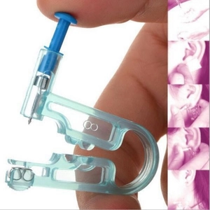 Detail of disposable ear piercing gun with positioning pen and needle set components
