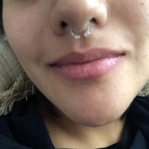 Macro shot of a transparent horseshoe nose ring in bio-plastic on a real model