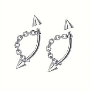 Detailed view of silver stainless steel lip and eyebrow rings with rhinestones and punk chains