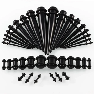 Detailed view of black acrylic ear stretching kit with tapers and tunnels in varied sizes