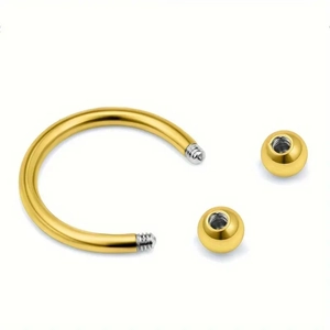 Detailansicht des goldenen Hufeisen-Piercings mit silbernen Gewinden und zwei Schraubkugeln
