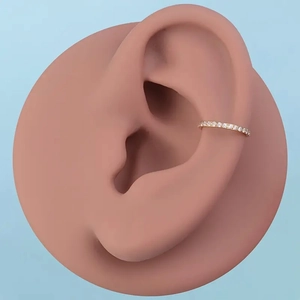 Detail of gold paved cubic zirconia seamless hinged clicker ring shown on an ear model