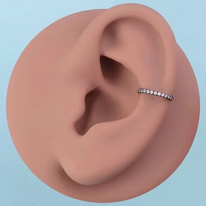 Detail of a black seamless 316L stainless steel ear cuff with sparkling white zircons