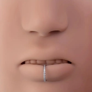 Macro close-up of a silver 316L stainless steel lip ring with paved white zircons