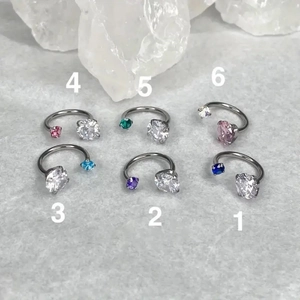 Macro detail of six horseshoe rings with brilliant AAA cubic zirconia in varied colors