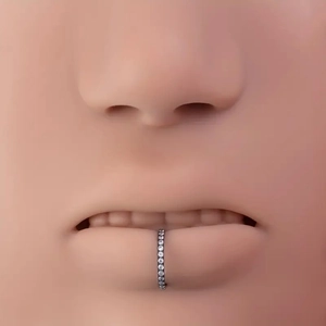 Detail of 316L stainless steel nose ring with clear zircon crystals on silicone model