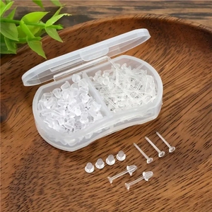 Vue détaillée de fermoirs et clous d'oreilles en silicone transparent dans une boîte de rangement