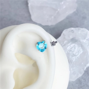 Close-up of heart-shaped blue zircon horseshoe ring on ear model with crystal decor