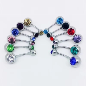 Primer plano de pedrería de colores en piercings de ombligo de acero inoxidable