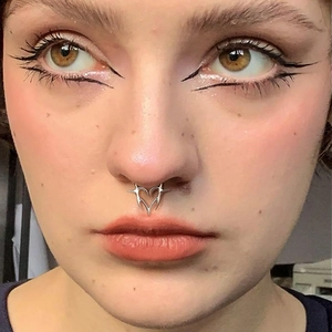 Silver G23 titanium 16G septum ring with heart and thorn spikes worn by a model