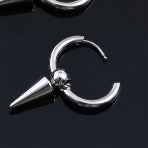 Macro shot of punk gothic stainless steel hoop earring with a conical spike pendant