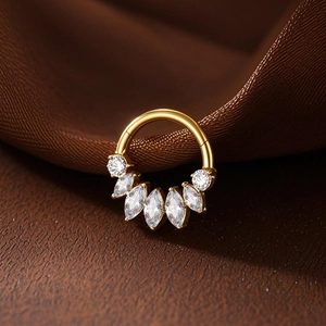 Macro shot of gold G23 titanium septum clicker with fan-shaped marquise-cut zircons
