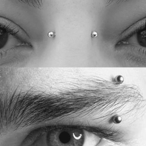 Detailed macro view of stainless steel eyebrow rings with mirror-polished ball design