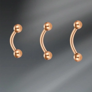 Macro detail of three rose gold 16G curved barbell rings with polished finish