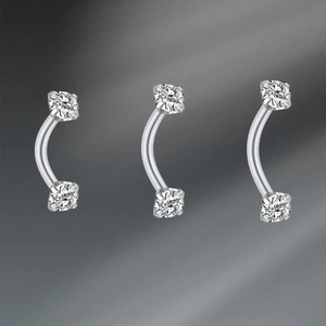 Macro shot of 16G curved barbell eyebrow rings with zircon stones on stainless steel