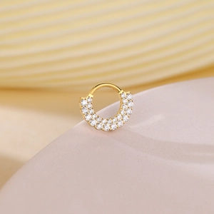 Detailed close-up of golden double-layered zircon hinged segment ring with paved stones