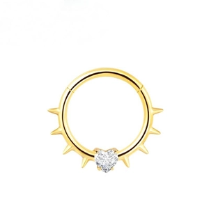 Macro detail of golden punk septum ring with heart CZ stone and spiked piercing design