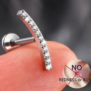 Macro shot of G23 titanium curved piercing stud with inlaid white zircons on flat back post