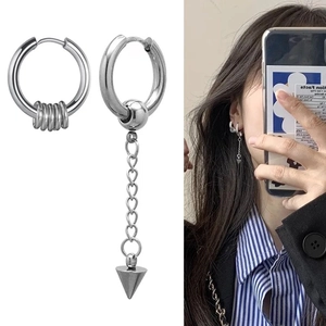 Detailed view of asymmetric punk earrings with long chain and spike pendant on model