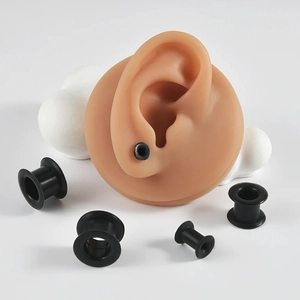 Vue détaillée des tunnels d'oreille en silicone noir flexible sur un modèle réel