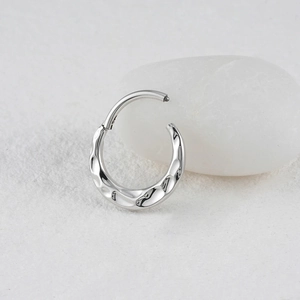 Detail of silver ASTM F136 titanium hinged segment ring with hammered texture finish