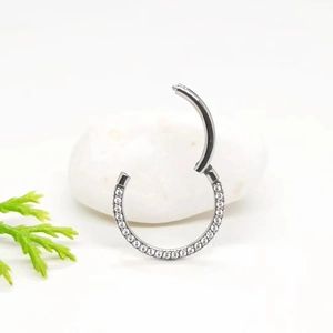 Detail of silver ASTM F136 titanium clicker hoop with white cubic zirconia stones