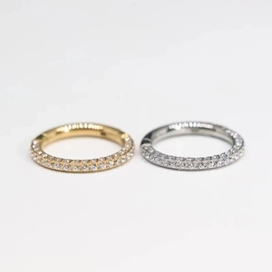 Detailed view of silver and gold titanium clicker rings with double-row cubic zirconia