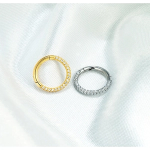 Detailed close-up of gold and silver titanium clicker hoops with double-row CZ inlay