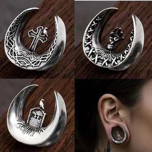 Macro detail of gothic stainless steel ear plugs featuring vintage RIP tombstone carving