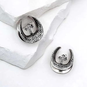 Detail view of retro silver crescent ear plugs featuring gothic cross and bird design
