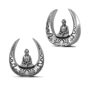 Detail view of retro silver U-shaped ear plugs with Buddha and lotus carvings