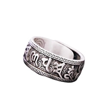 Macro shot of silver ring featuring engraved Sanskrit mantra and vintage pattern details