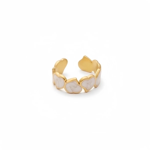 Detailed close-up of gold open ring featuring linked white marble heart patterns