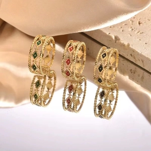 Detailed macro shot of vintage gold braided rings with green red and black enamel inlays