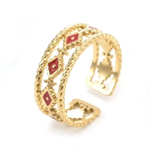 Detailed close-up of golden adjustable ring with red enamel diamond patterns and rope texture