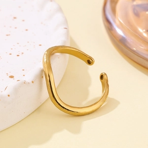 Elegant gold S-shaped wave open ring with hammered texture on a minimalist background