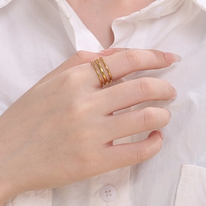 Minimalist gold-plated stainless steel triple band ring on model's finger with a glossy finish