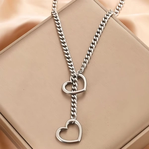 Collana a catena cubana in acciaio argento con ciondolo a cuore su raso champagne
