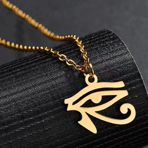 Vue détaillée du pendentif œil d'Horus doré sur une chaîne en acier inoxydable vintage