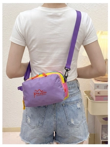 Close-up of waterproof nylon crossbody bag with purple straps and colorful patchwork design