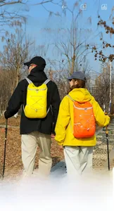 Close-up of yellow and orange folding backpacks with bungee cords for hiking and camping