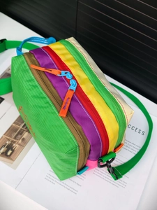 Detailed close-up of water-resistant nylon crossbody bag with colorful rainbow patchwork design