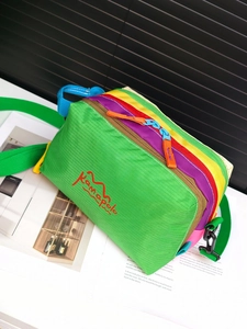 Close-up of colorful waterproof nylon crossbody bag with logo and tri-color zippers