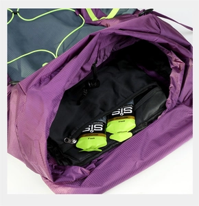 Detail view of the purple hiking backpack showing zippered inner pocket and drawstring closure