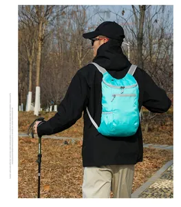Outdoor model wearing a lightweight cyan waterproof folding backpack on a forest trail
